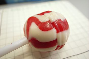 Red and white lollipop on checkered paper.